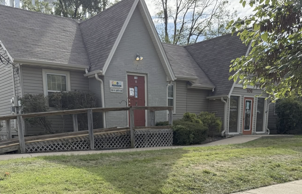 A residential looking building with a accessible entrance and a red door shows the Garth location where supply donations can be made.